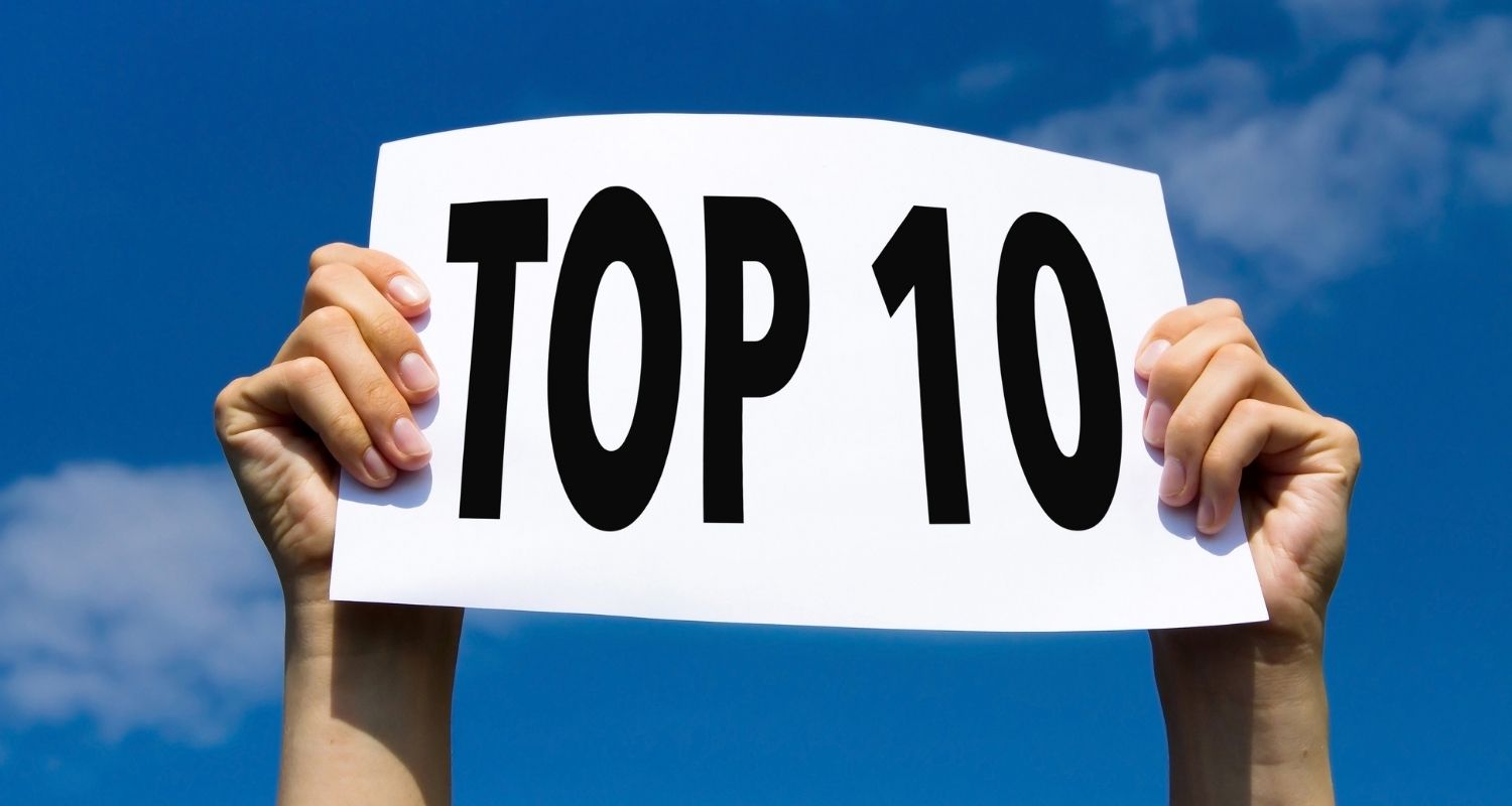 A pair of hands holding a card with inscription top 10